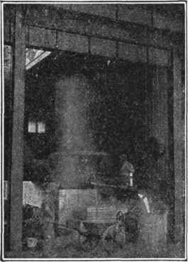 Fig. 186.   Drawing Iron from Cupola. When the iron has been melted down in the furnace it is drawn from the cupola into large ladles which are picked up by the overhead traveling cranes and taken to the flasks where later it is poured.