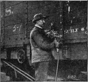 Fig. 8.   A power tool (compressed air attachment) tightening nuts on a freight car. Compressed air may be utilized in this way to screw on nuts and thus save the mechanic's strength.