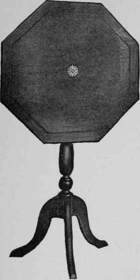 A tilt top table with a turned column. The top is decorated with an inlaid insert and border.