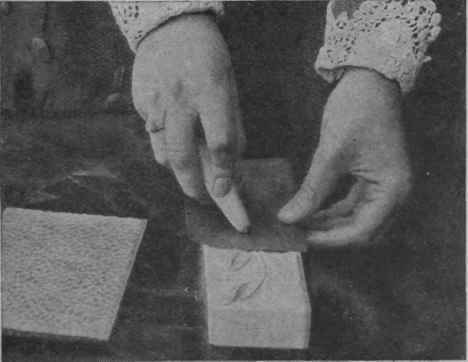 How to begin a piece of work. The metal is fastened over the mould, and by means of gentle, even pressure forced gradually into its shape by the tool. A sheet of ripple glass is at hand by which a hammered background effect can be produced