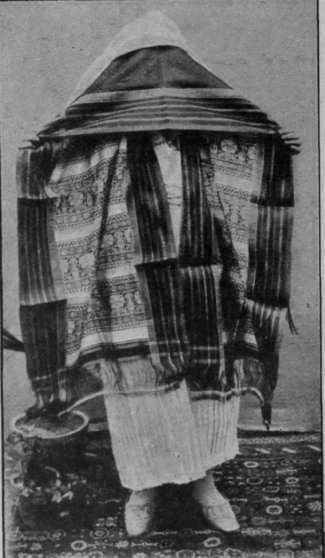 A Tunisian lady of the upper classes, wearing the voluminous and auaint looking veil demanded by her position