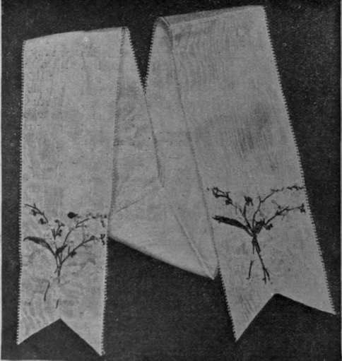 A forget me not design for a table ribbon of white moire silk. The flowers and leaves are worked in their natural colours, and the embroidery is both delicate and beautiful in execution