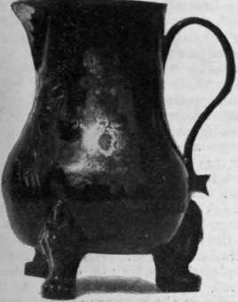A jug in Elers' ware, ornamented with a floral design and supported on three feet