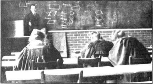 Students attending a lecture on surveying. They are constantly taught the doctrine of hard work, and are prepared early for future arduous conditions to which their professions will subject them