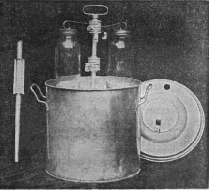 The stand, with the tars in position, being placed in outer pan. The thermometer is put through hole in lid when it is placed over the vessel