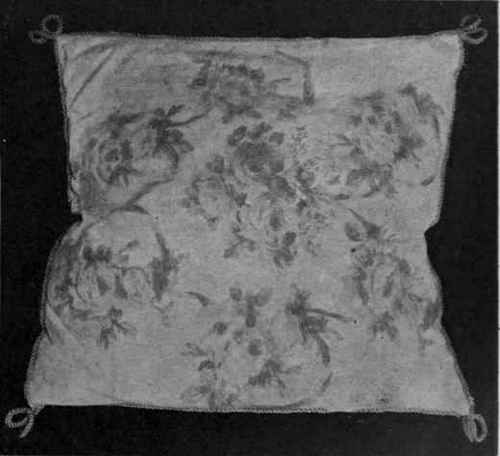 A cushion cover of cretonne roses appliqued upon white satin and covered with coarse white net. A few beads sewn on would give the appearance of dewdrops upon the roses
