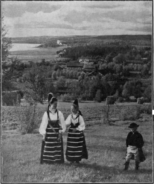 Dalecarlian girls, in their picturesque national dress, strolling through the fields outside Rattvik. Old customs are still preserved in Sweden, especially those belonging to the marriage ceremony