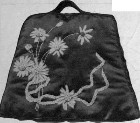 Marguerites or ox eyed daisies are particularly effective in applique on black satin; pale mauve ribbon studded with beads connects the flowers
