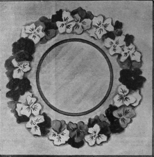 Pansy blossoms arranged closely together without foliage form an artistic decoration for a photograph frame