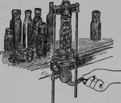 >Fig. 39 - A hand machine for putting on cork-lined metal-sealed caps. With one of these machines, bottles of all kinds can be utilized for pickles and preserves. The caps can be bought in assorted sizes, and a neat, tight, easy job is made of sealing.