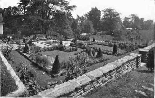 Fig. 118.   The natural background on an adjoining property makes a good setting for the garden. Gray sandstone enclosing walls with similar coping stone.   See pages 133, 138, 140 149.