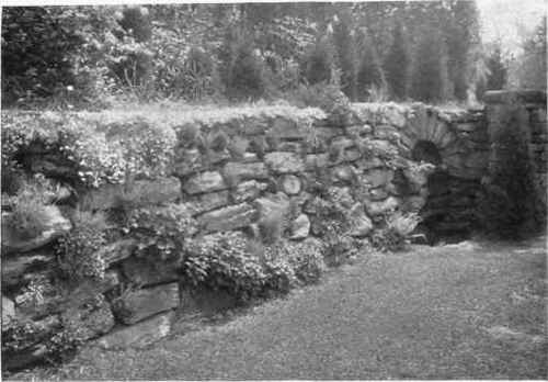 Fig. 172.   A dry retaining wall with pockets for plants, where the water feature adds greatly to the scene.   See page 226.