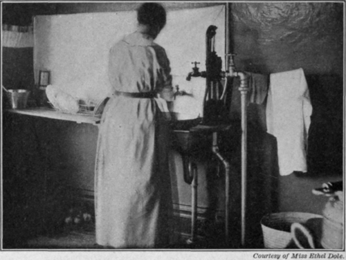 Fig. 60.   Washing dishes. Notice the rack at the left for draining dishes.