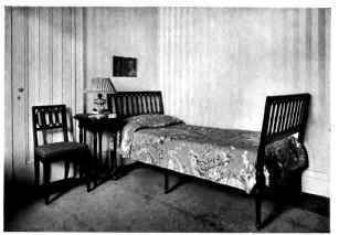 A YOUNG MAN'S BEDROOM WITH BACKGROUNDS OF WALL PAPER AND RUG EXPRESSING RESTFULNESS AND QCIET