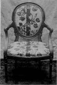 Upholstered Oval Back, Single Curve Arm Supports, Round Tapered Legs.