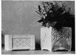 Two widely different types of flower boxes. To the right are simple small ones, while at the left is a large ornamental one used for window or balcony ornament.